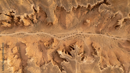 Aerial view of desert landscape with rocky formations and winding dirt road