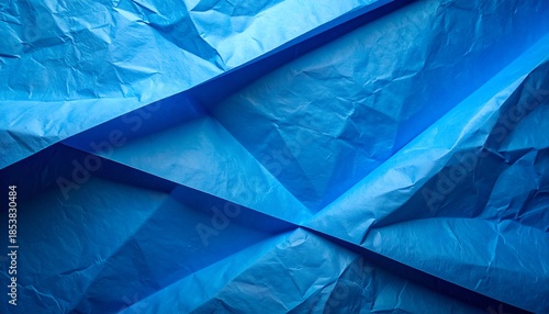 折り重なった青い紙の質感が立体的に広がる背景素材イメージ