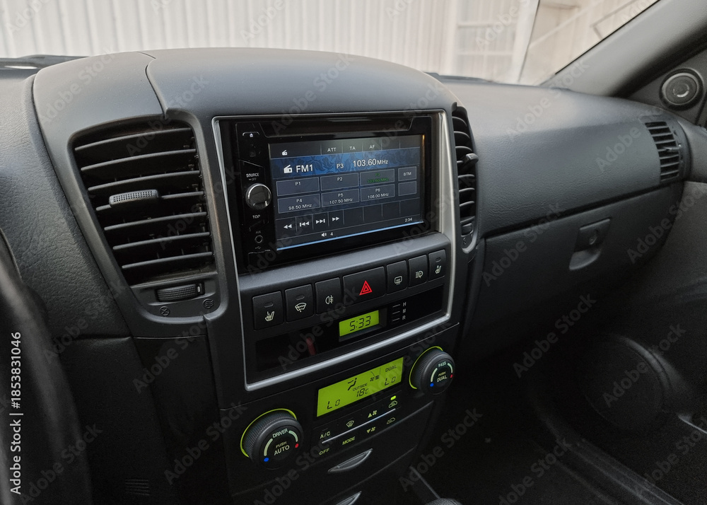 Fototapeta premium Close up shot of infotainment system in old car. Listening to radio while driving in a city in late afternoon. 