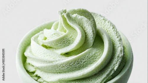 Delicious swirl of matcha green tea ice cream in a small bowl against a white background