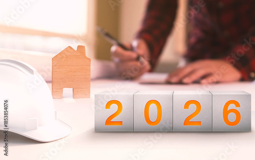 Happy New Year 2026. Construction and Industry.White Helmet and a numbered concrete cube on the desk of an engineer or architect.  construction industry concept.