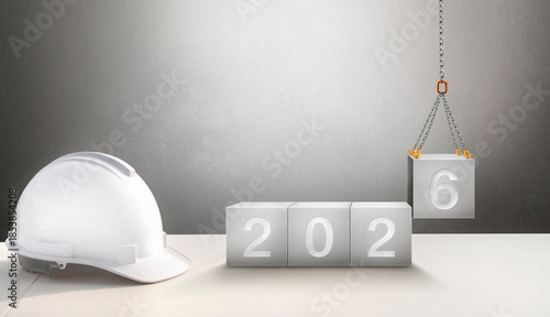 Happy New Year 2026 Construction and Industry. White Helmet and a numbered concrete cube on the desk of an engineer or construction worker. building with Cranes construction concept.