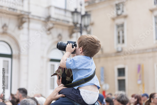 Little boy on shoulders learning photography skills