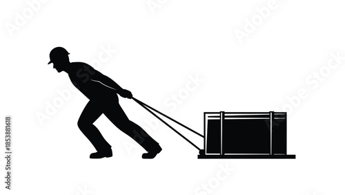Silhouette of construction worker in hard hat powerfully pulling a heavy crate or cargo using ropes