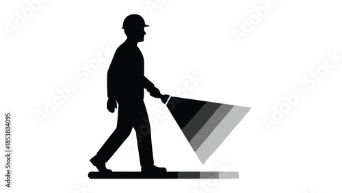 Silhouette of a construction worker wearing a hard hat walking forward holding a bright flashlight