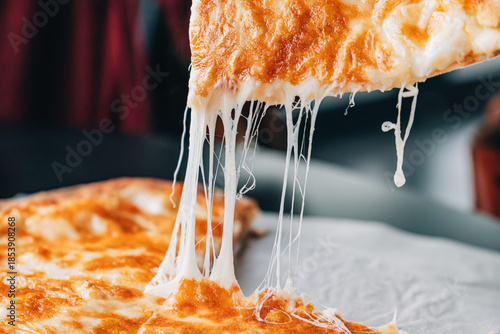 Photos Pizza or Imeretian khachapuri slice lifting with hot melted cheese creating a st