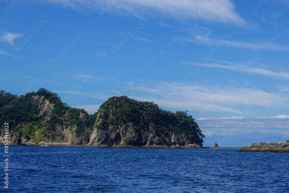 Fototapeta premium Open blue sea stretching toward distant cloud band horizon