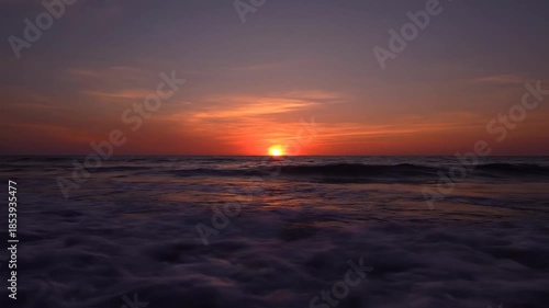 Golden Hour Sun Setting Over the Gentle Sea Horizon.