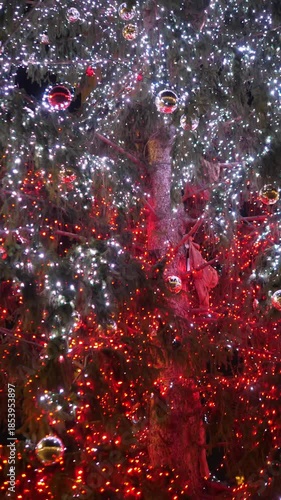 Vertical: A close view of the Christmas tree lights placed in St Peter Square. The glowing decorations create a warm and festive holiday atmosphere at night.