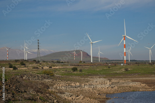 wind farm with turbines on Golan Heights in Israel near the Bental reservoir converting wind energy to electricity.