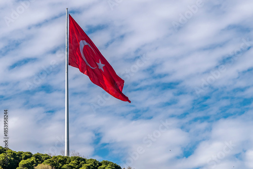 A giant Turkish flag flies on a hill overlooking the Bosphorus Strait, Istanbul, Türkiye