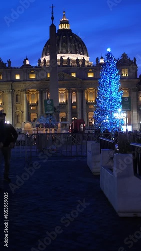 Vertical: St Peters Basilica appears at night in Rome, with the Christmas tree fully illuminated. The scene is highly evocative, calm, and filled with a strong holiday atmosphere.