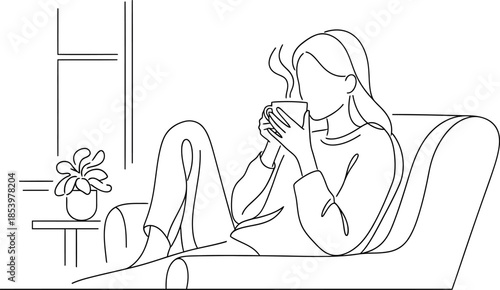 Woman sitting on a couch drinking a hot beverage by the window with a plant