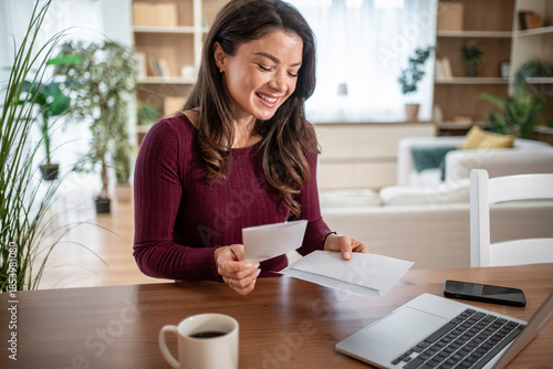 Photos Woman smiling opening mail letter receiving good news