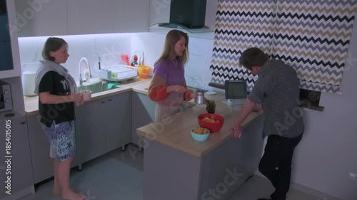 casual snack prep, relaxed gathering with snacks and conversation, casual apartment scene with adults preparing and sharing snacks, relaxed kitchen gathering where adults pass snacks and chat