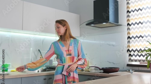 woman cooks breakfast, caucasian woman prepares morning meal, woman cooking breakfast in modern kitchen setting, female caucasian preparing breakfast in contemporary kitchen with sizzling pan