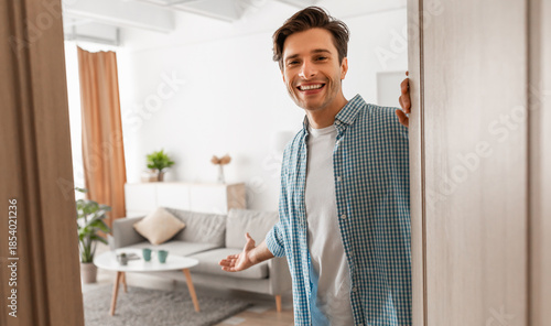Φωτογραφία Portrait of cheerful man welcoming inviting visitor to enter his home, happy you