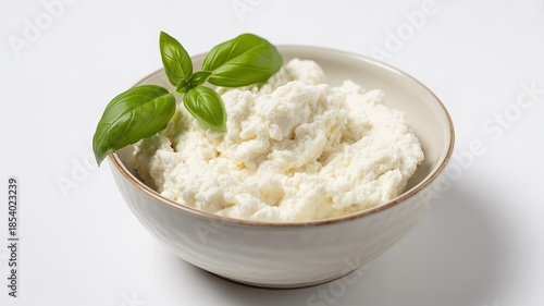 Ricotta cheese in white bowl with basil garnish creamy dairy fresh organic protein food background