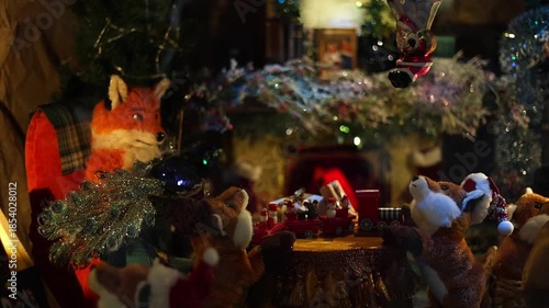 4K video of a New Year shop window display filled with various Christmas toys and festive decorations. Colorful ornaments, figurines, lights