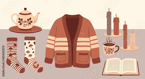 Cozy autumn still life featuring a brown cardigan knitted socks a teapot with tea warm candles and an open book on a table.
