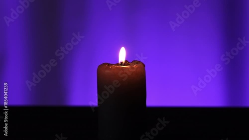 Woman Lights A Candle With A Lighter Against A Blurred Blue Background