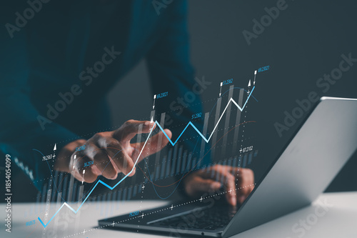 A person interacting with a laptop displaying digital graphs, suggesting analysis or data visualization in a modern business environment.