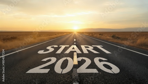 The beginning of 2026, written on an endless asphalt road at dramatic golden hour sunrise, representing new year resolutions, future aspirations, and the path to success.