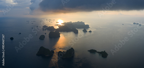 Sunrise illuminates rock islands, composed of ancient, uplifted reefs, rising from the seascape in Misool, Indonesia. This region harbors spectacular marine biological diversity and is a popular desti