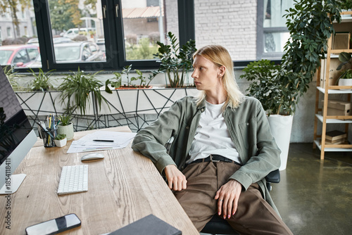 Fotografie Stylish non binary person enjoying a moment of reflection in a modern workspace
