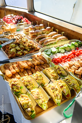 Tasty taco buffet and more. A vibrant buffet spread showcases tacos, sliders, and fresh vegetables, perfect for any gathering or event.