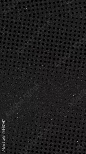 Black metal with perforation close up macro background pattern