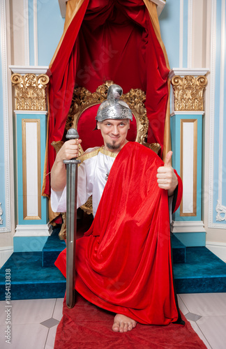 Confident funny smiling man wearing medieval costume showing thumbs up