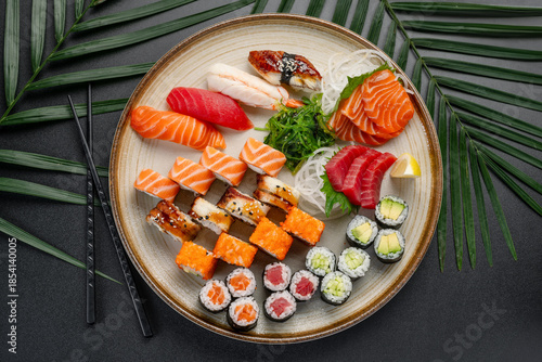 Large Sushi and Sashimi Platter with Edamame and Crab. An extensive platter displays a full selection of sushi, sashimi, and maki rolls, including crab and edamame, surrounding seaweed.