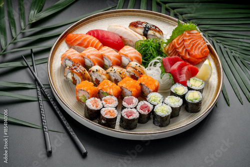 Diverse Platter of Sushi, Sashimi, and Maki Rolls. A circular platter presents a rich variety of nigiri, sashimi, and maki rolls, showcasing tuna, salmon, eel, and avocado fillings.