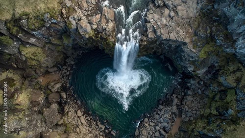 A breathtaking photo of a large waterfall releasing a torrent of water into a rocky pool below A heart made of cascading waterfall