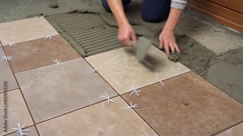 Home improvement laying tiles with cement mortar for floor installation and renovation project
