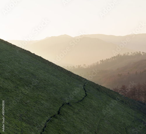 A path winds across a green meadow at the top of Bianditz, between Gipuzkoa and Navarre.