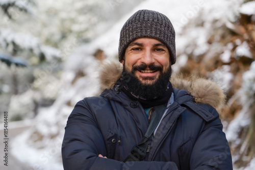 Smiling bearded man in the snow looking at camera