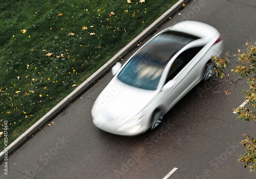 white sedan car moving at autumnal street
