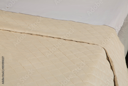 Elegant modern bedsheet with soft fabric texture, neatly arranged on a bed, showcasing comfort, cleanliness, and contemporary bedroom interior design