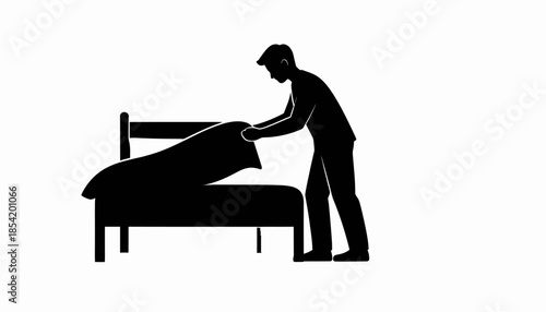 Silhouette of a person making a bed in a bedroom.