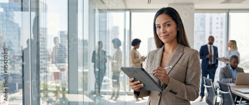  Smiling latin hispanic young woman using pad computer for business app. Busy executive CEO businesswoman professional holding digital tablet pc device for work in modern office. Banner, copy space 