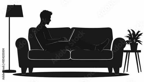 Silhouette of a person working on a laptop while sitting on a sofa at home.