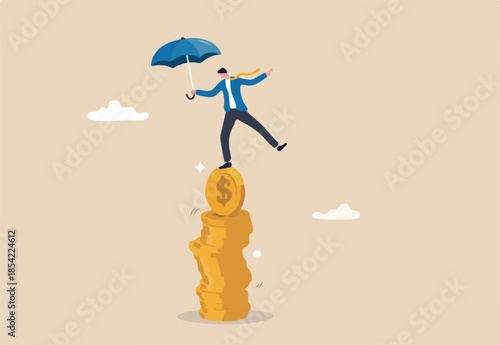 Financial stability, risk or trust, economic challenge, balance or reliability, money management, security or wealth accumulation concept, businessman hold umbrella balance on unstable coins stack.
