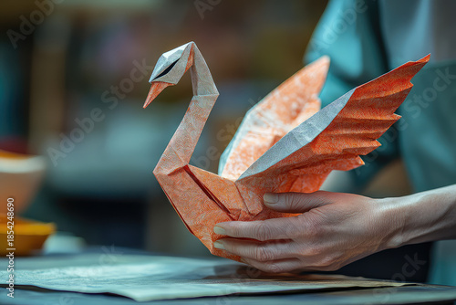 paper swan origami in human hands