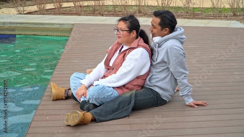 Asian woman with eyeglasses sharing a romantic moment with his husband who kisses her with love