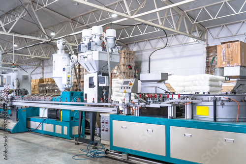 Tableau sur toile Plastic extrusion manufacturing machine in modern industrial factory, automated polymer processing line for plastic products production with raw material and control panels