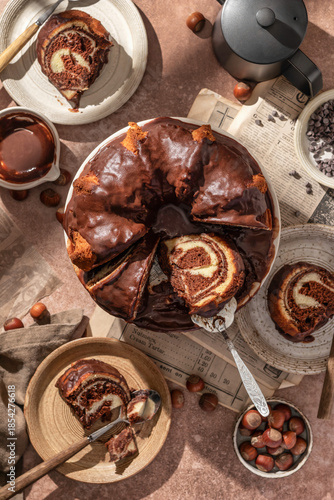 Chocolate marble bundt cake or zebra cake with chocolate glaze sliced on brown table background top view