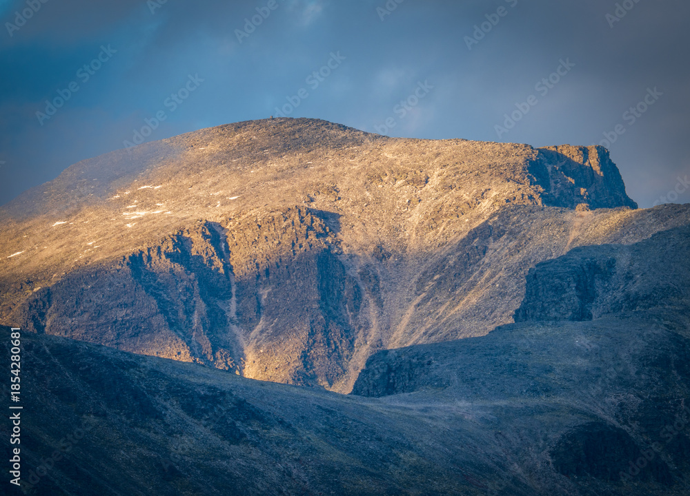 Naklejka premium Rocky mountain face illuminated by low sunlight in Rondane