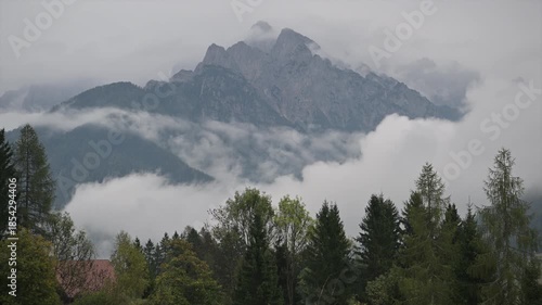 Clouds Cover Slovenian Mountains in the Early Morning Light Near a Forest Area